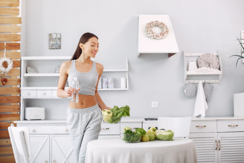 Beautiful Sporty Woman Kitchen With Vegetables